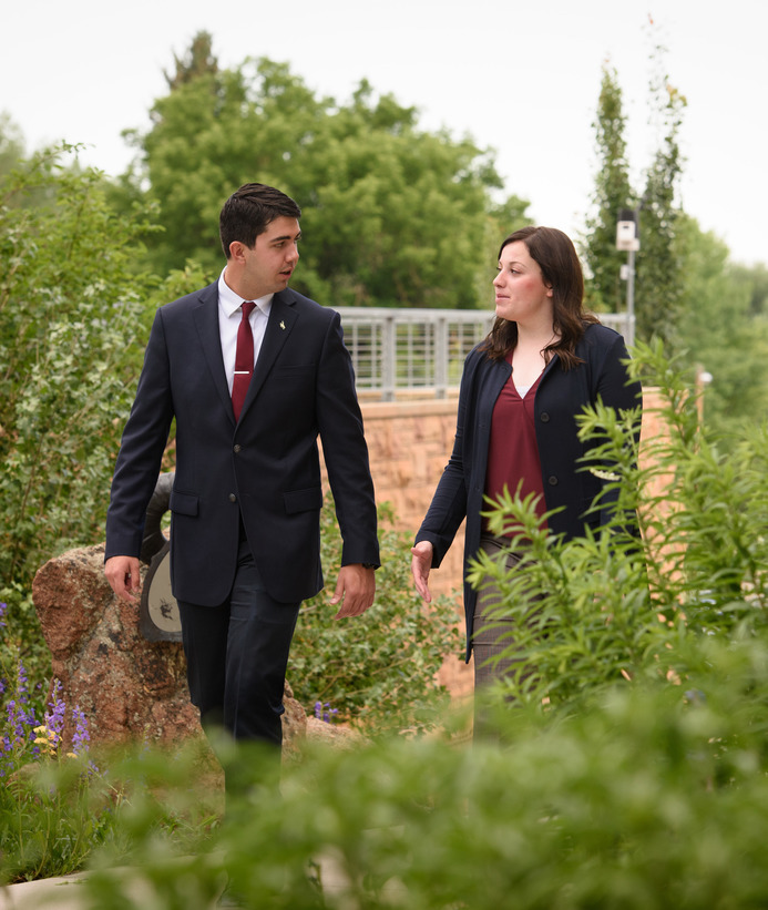 Two people walk together through a garden