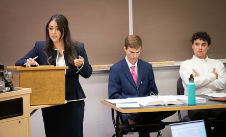 Three students participate in a mock trial during class