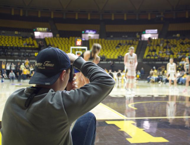 Student taking photos at a UW basketball game