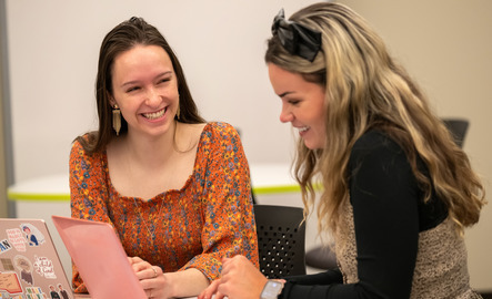 Two students smile while studying