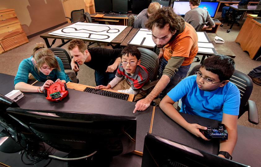 Teachers helping students at computers