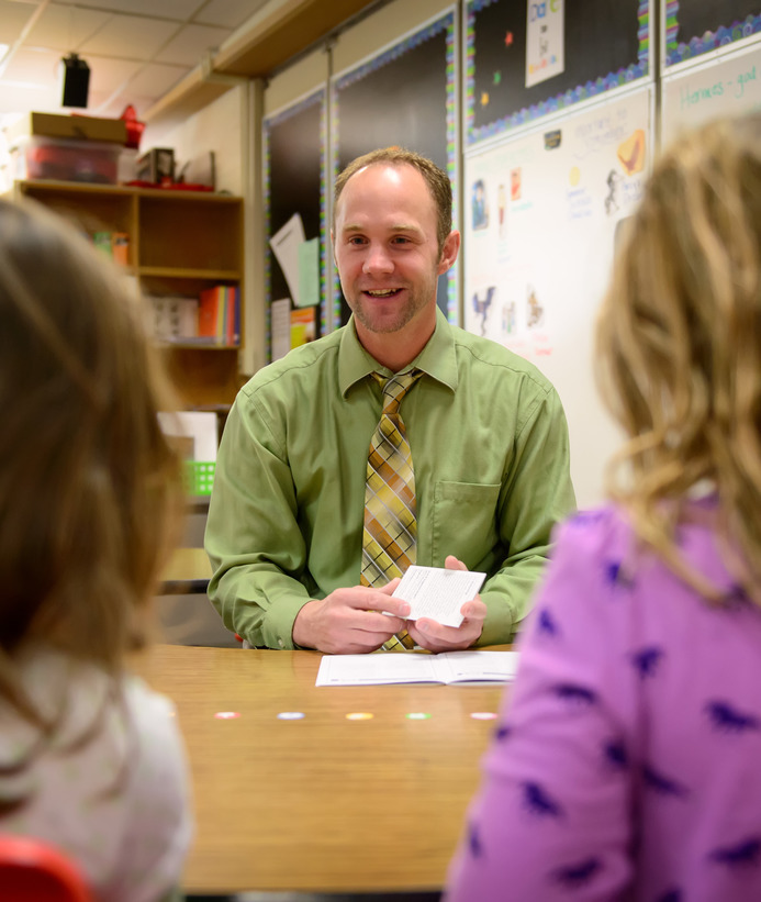 Literacy teacher working with two students at table