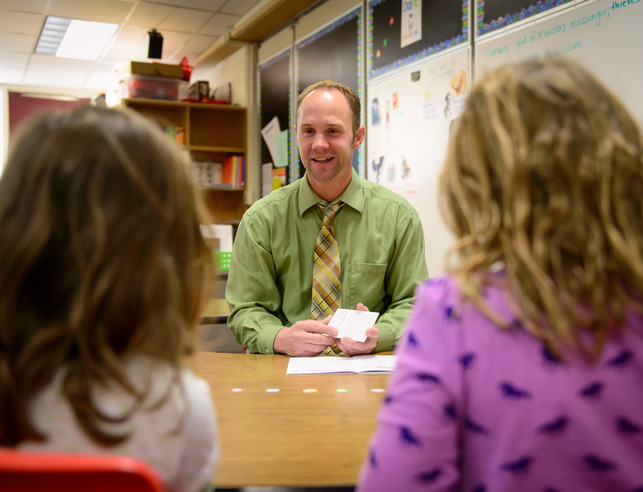Literacy teacher working with two students at table
