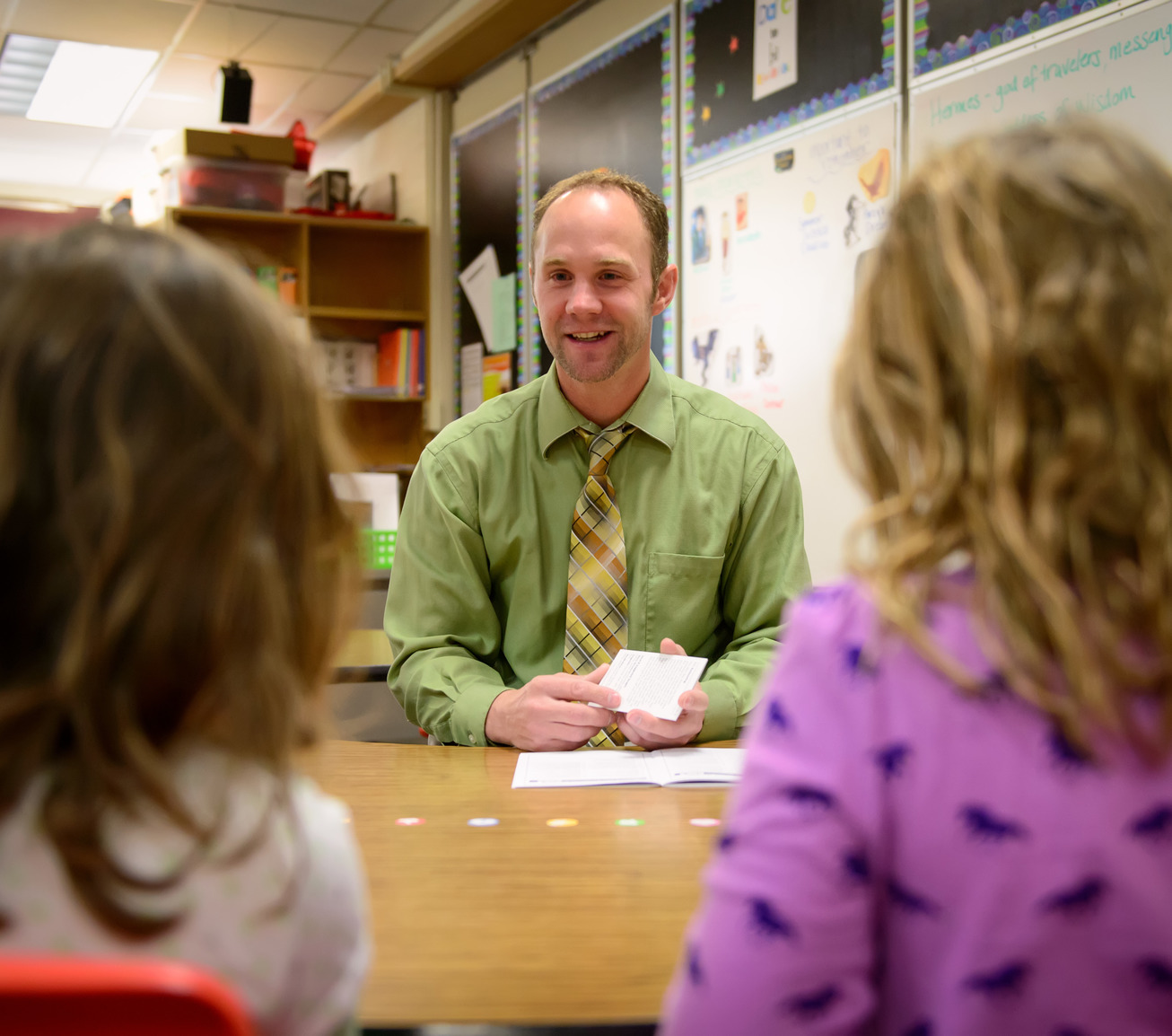 Teacher working with two students at table