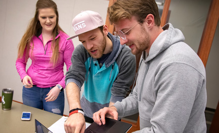 Three students work on the computer