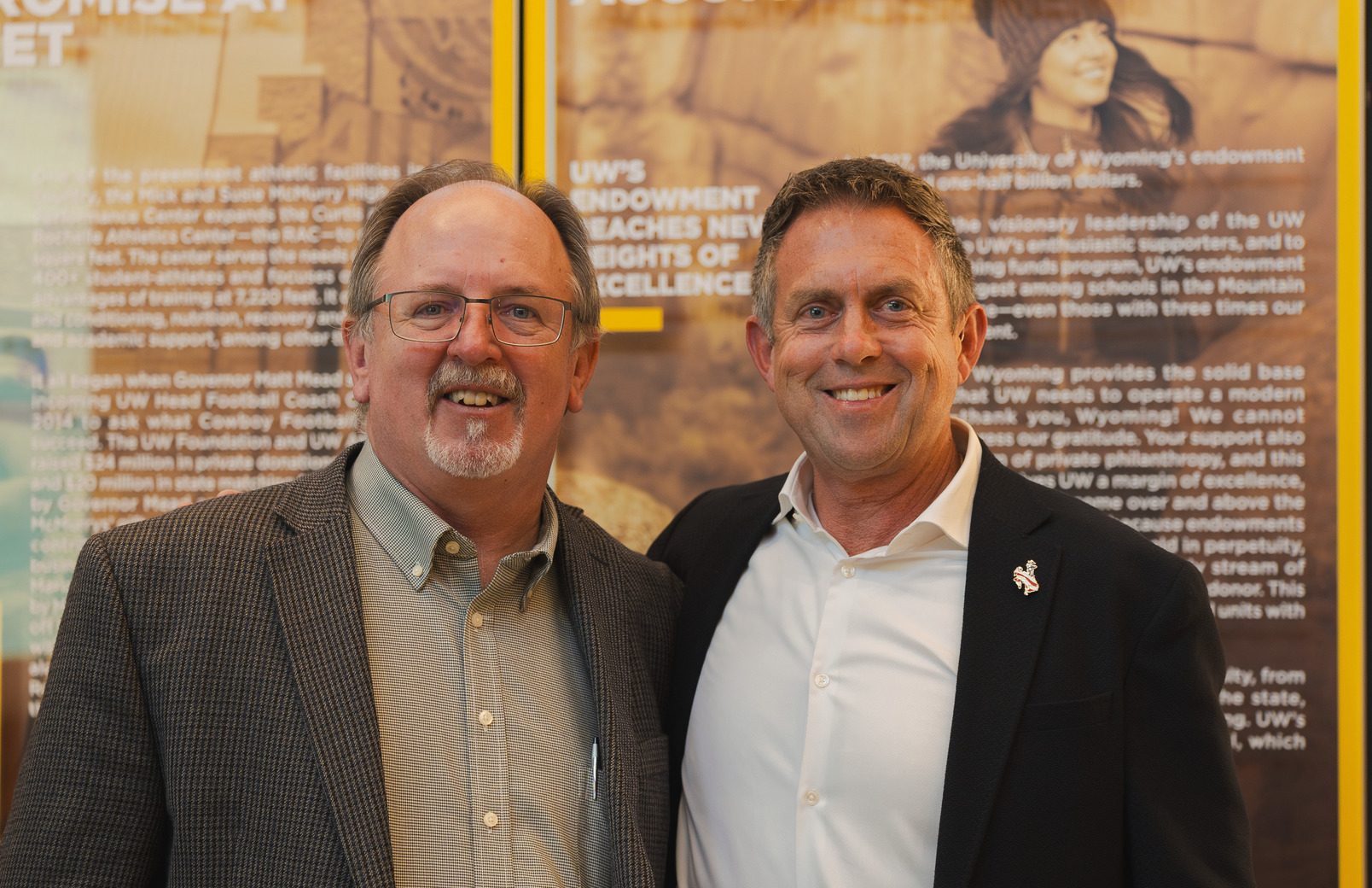 Two men smile for a picture