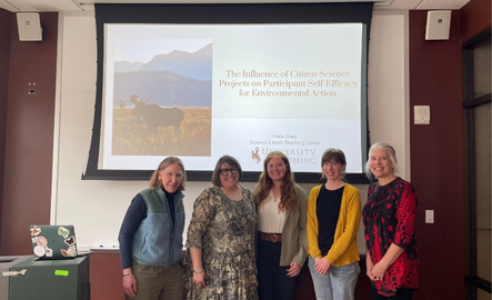 Group of teachers smile in front of a presentation