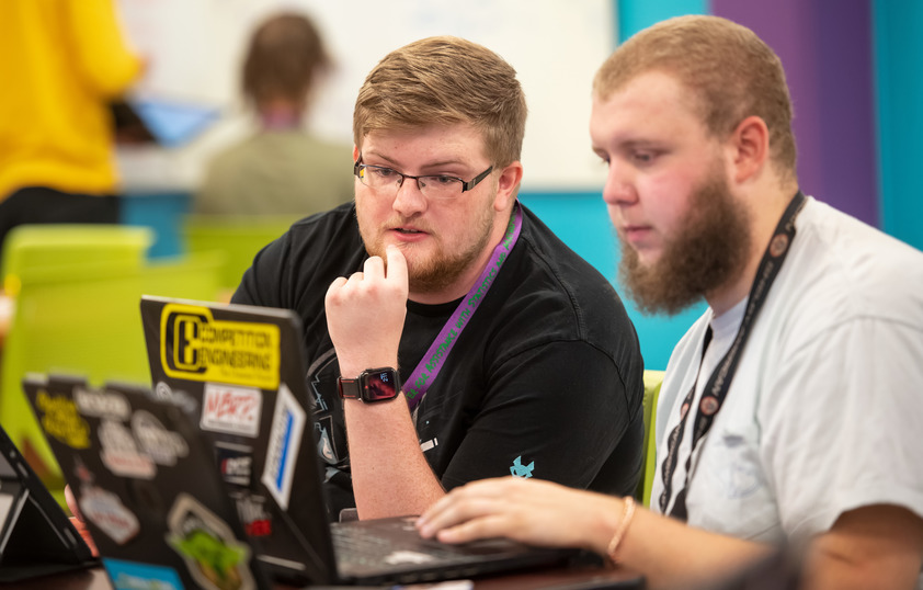 Two students working on a laptop together