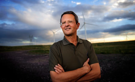 Mathematics professor stands in front of windmills