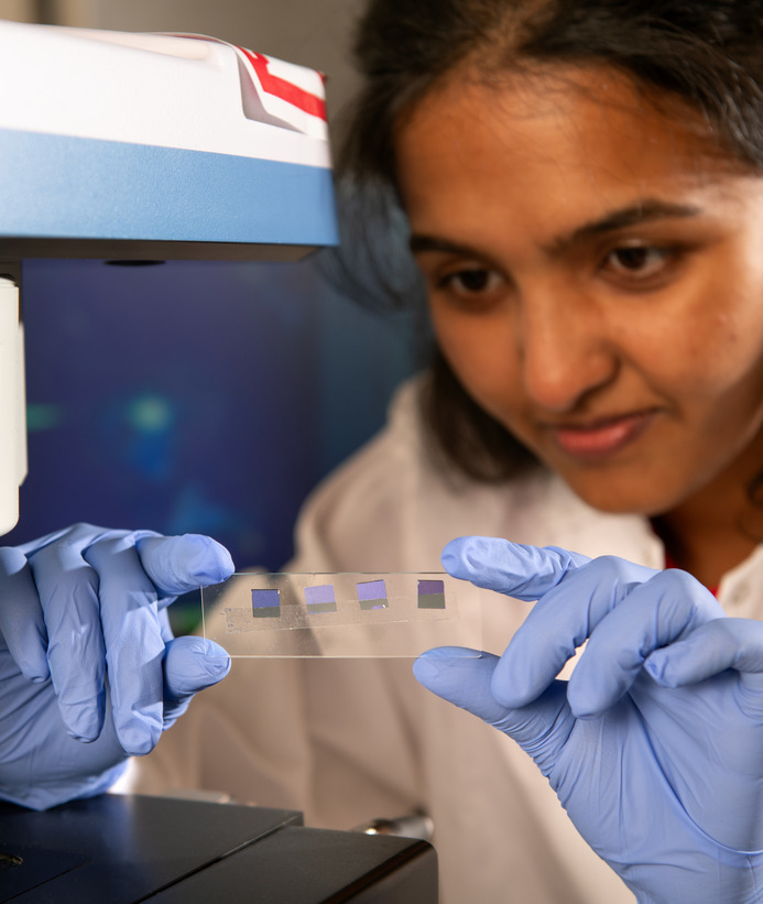Student holds up a slide with microchips