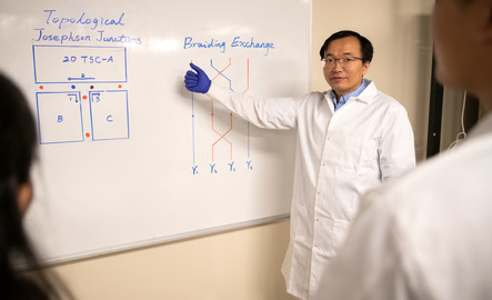 Quantum engineering professor points to a dry erase board