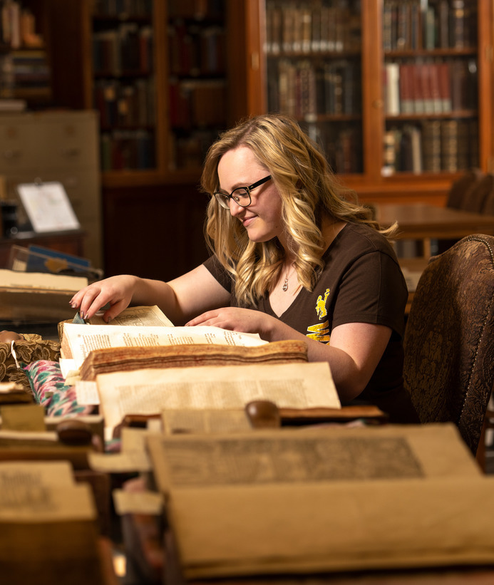 Student looks at books in a museum