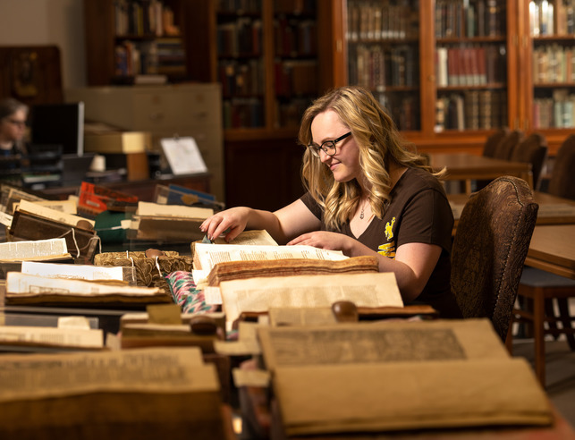 Student looks at books in a museum