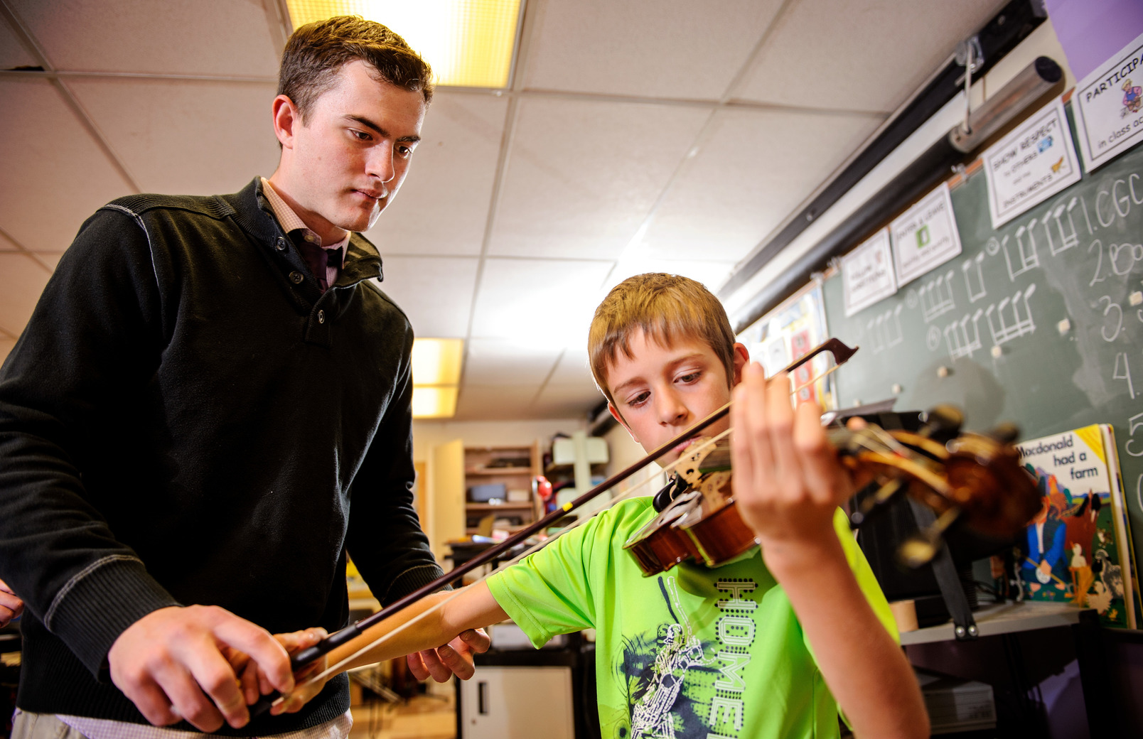 Teacher helping student with violin