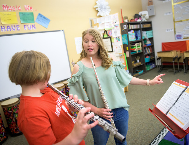 UW music education student teaches elementary student to play the flute