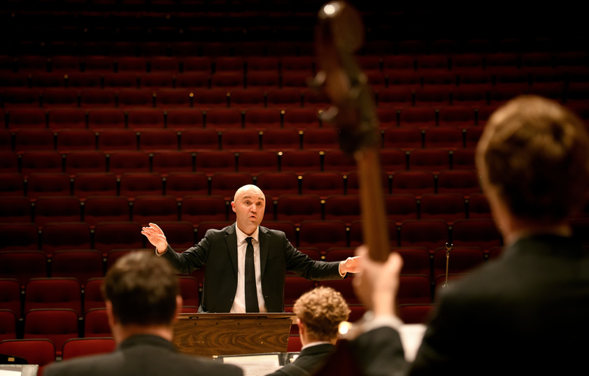 a conscertmaster guiding a performance