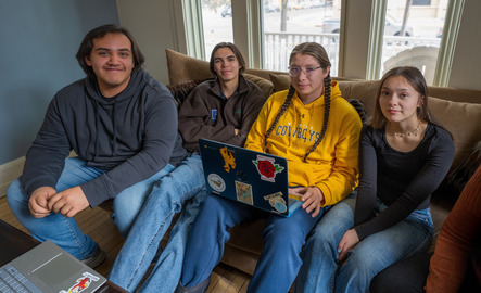 A group of students sit on a couch together