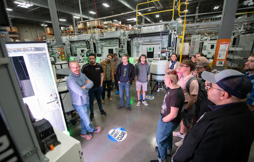 A professor teaches a class in a warehouse