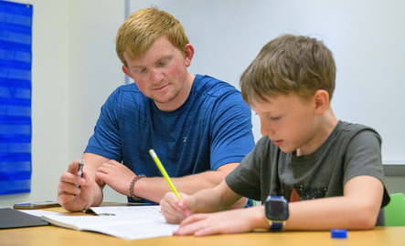 A teacher works on classwork with a student