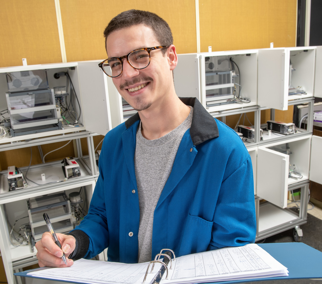 Student in lab and smiling for camera