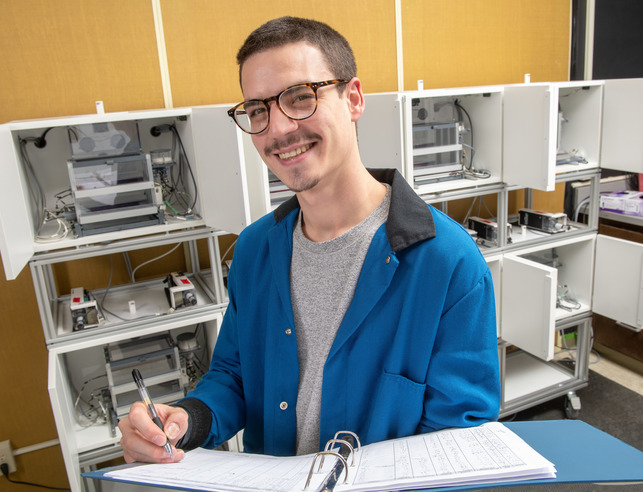Neuroscience minor student takes notes while smiling at the camera