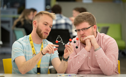 Two students look at a model of a molecule