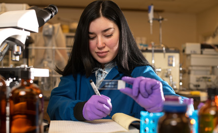 Researcher looks at a microscope slide