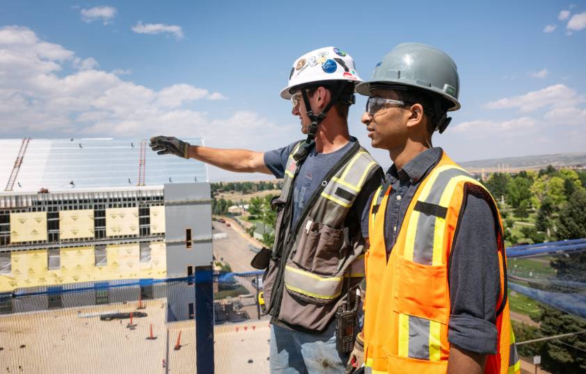Two people overlook a construction site