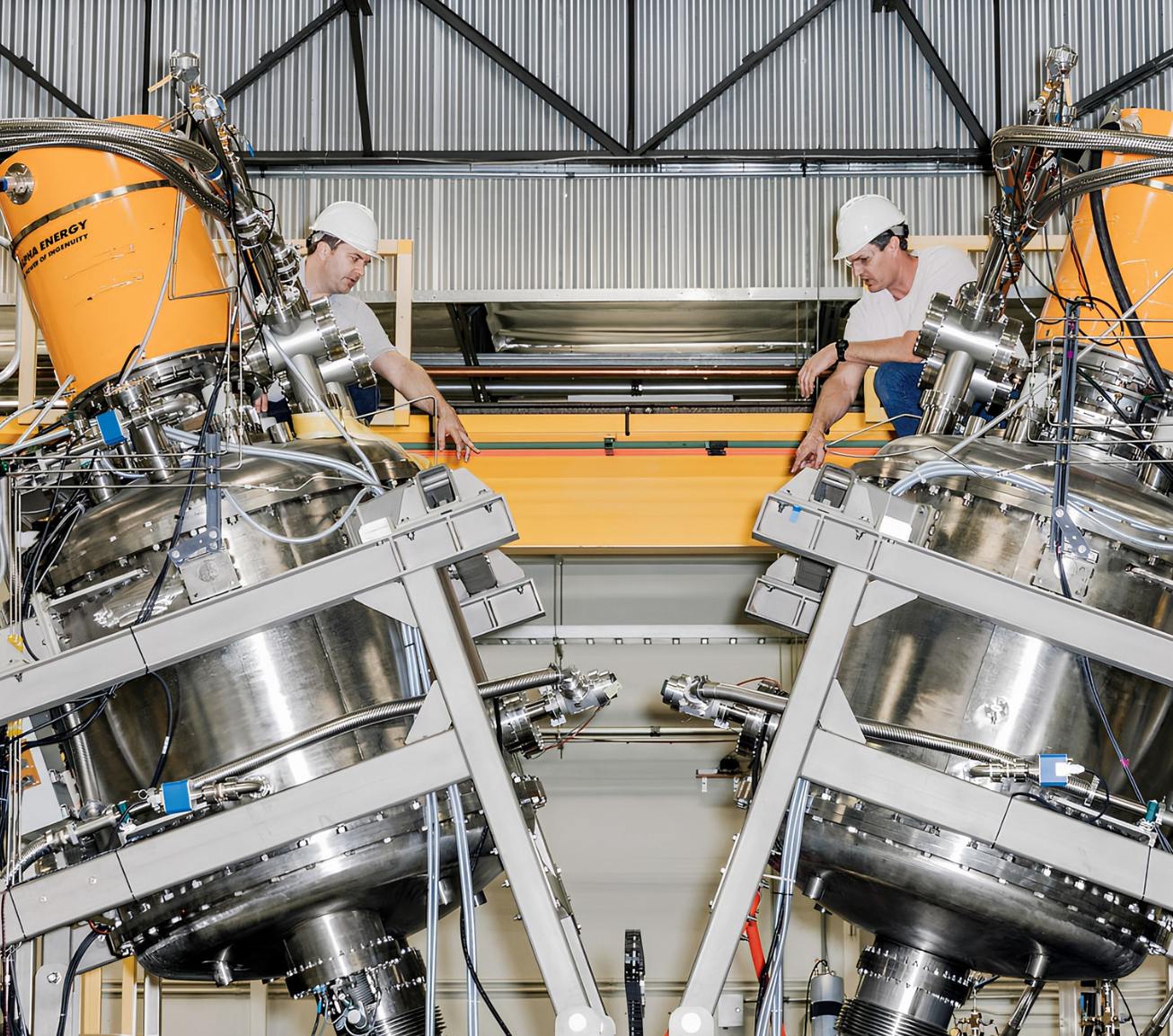 Two people in a lab with hard hats on