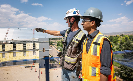 Two people overlook a construction site