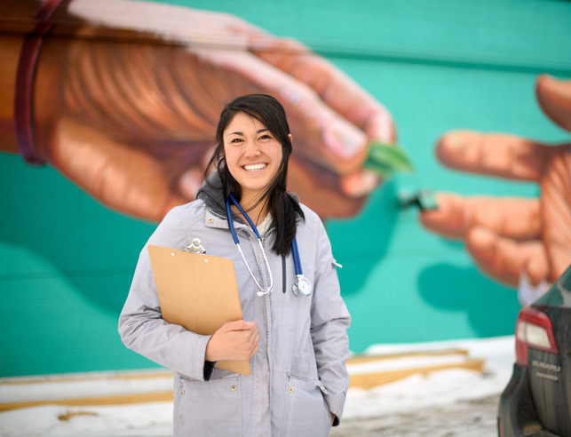 Nurse standing in front of mural
