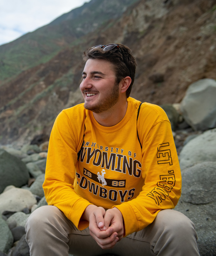Student smiling off into the distance on a beach during a study abroad trip