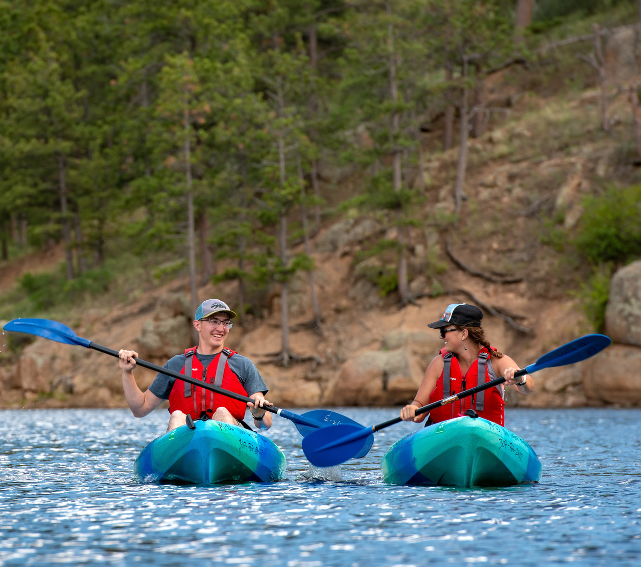 Two students smiling at each other while kayaking