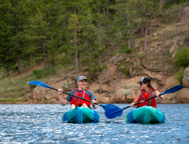 Two students smiling at each other while kayaking