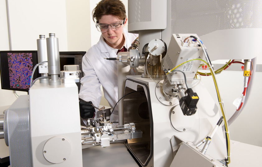 A professor and student smile for a picture in a lab