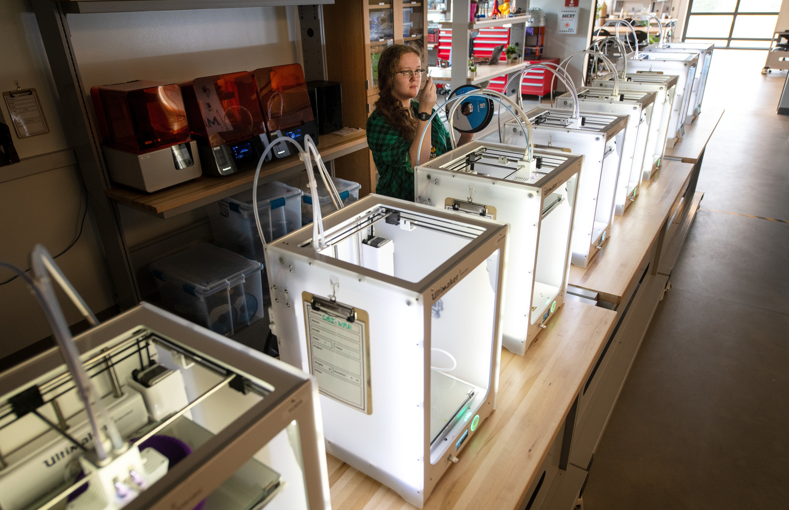 A student works on one 3-D printer in a row of 3-D printers