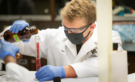 A student measuring a substance in a tube during a lab