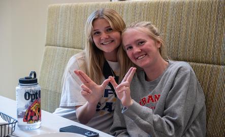 Two students make a "W" with their hands