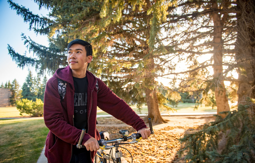 Student riding bike on campus