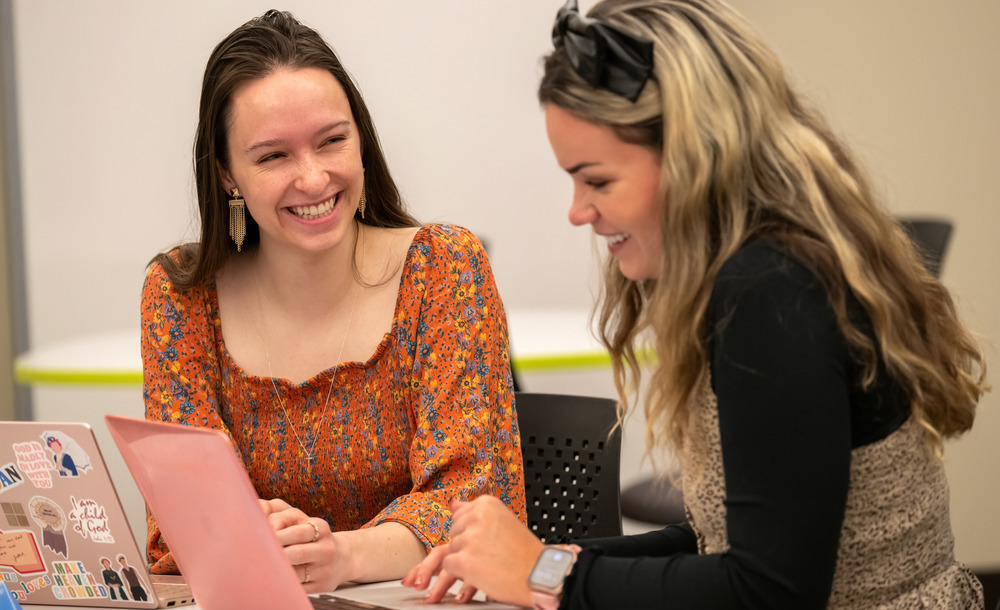 Two students work at a desk together