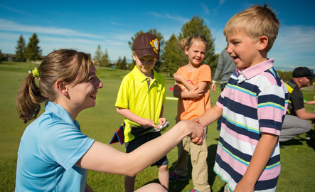 Physical education teacher shaking hands with an elementary student