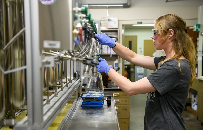 A student stands in the physics lab and works on things