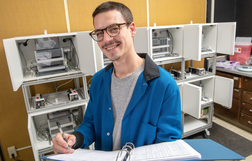 Researcher in a science lab documenting data