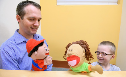 Teacher and student participating in play therapy with puppets