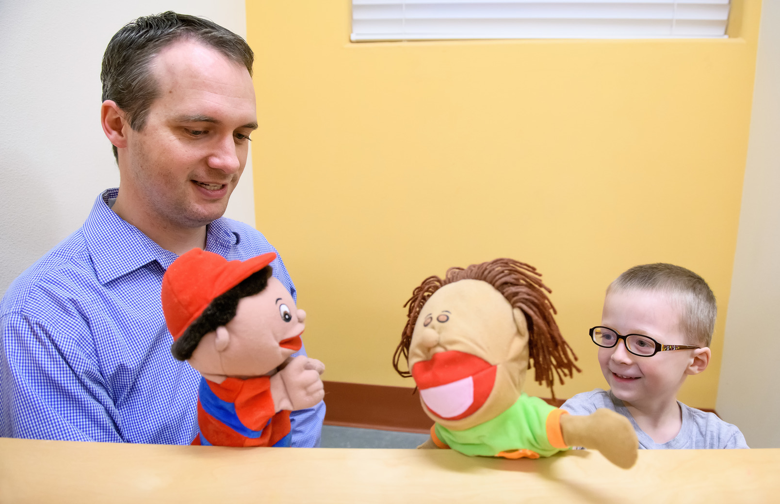 Counselor playing with puppets with client