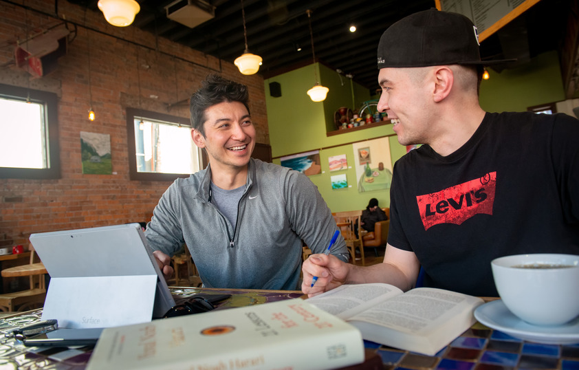 Two students study together at a coffee shop