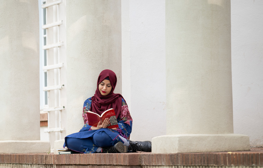 A student reads a book outside