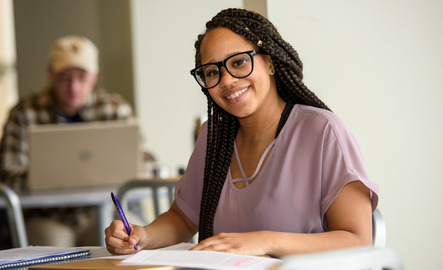 Student smiles while writing