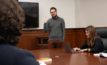 Professor talks to a table of students