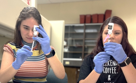 Two students fill syringes